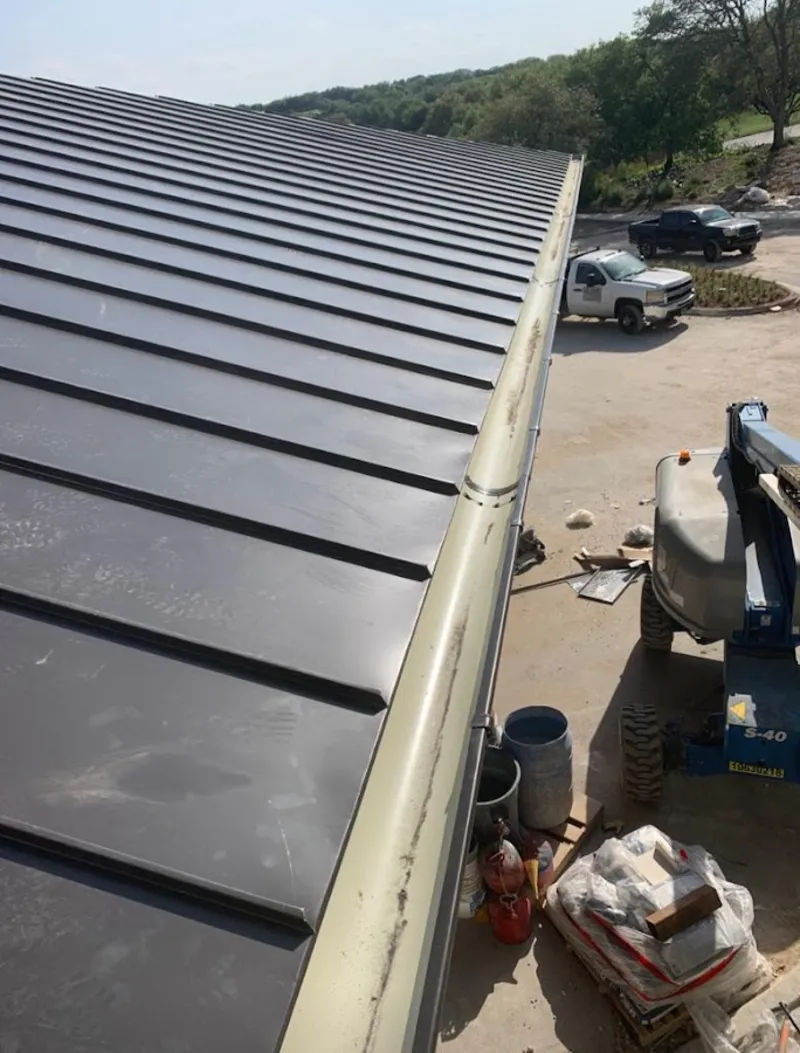 Standing seam panel and gutter detail on a metal roofing jobsite in Gardiner
